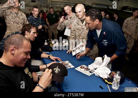 1003288936G-226 GIBUTI (28 marzo 2010) il tight end dei New Orleans Saints Billy Miller, a sinistra e il quarterback dei New Orleans Saints Drew Brees firmano autografi per Sailors and Marines nella baia dell'hangar della nave d'assalto anfibio USS Nassau (LHA 4). Miller e Brees visitarono Nassau come parte di un tour uso. Nassau è la piattaforma di comando del Nassau Amphibious Ready Group che supporta le operazioni di sicurezza marittima e le operazioni di cooperazione di sicurezza del teatro nell'area di responsabilità della 5th Fleet. Foto Stock