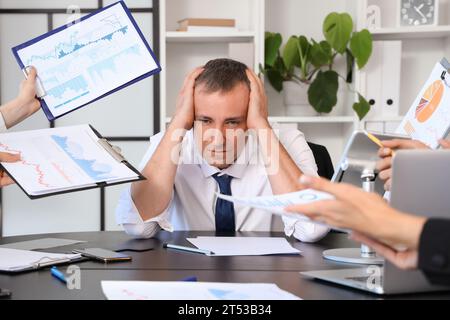 Uomo d'affari maturo che soffre di colleghi rumorosi in ufficio Foto Stock