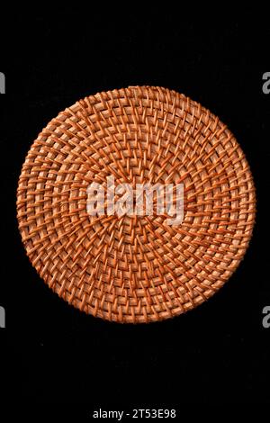 Sottobicchieri autunnali in rattan intrecciati, tovaglioli su sfondo nero Foto Stock