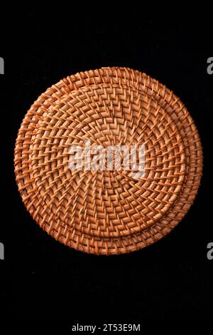 Sottobicchieri autunnali in rattan intrecciati, tovaglioli su sfondo nero Foto Stock