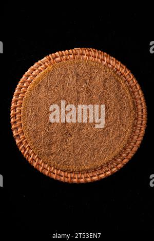 Sottobicchieri autunnali in rattan intrecciati, tovaglioli su sfondo nero Foto Stock