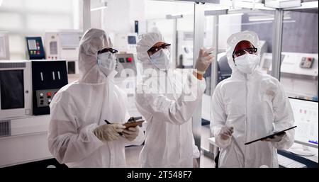 Fabbrica di produzione di semiconduttori sterile e lavoratori in tute Foto Stock