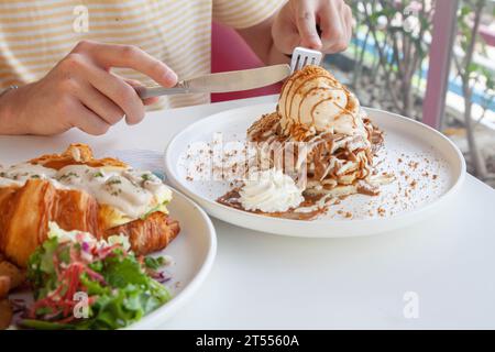 Uomini che mangiano pancake con gelato in un ristorante caffetteria e caffetteria. Foto Stock