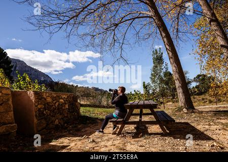 donna seduta in un'area picnic che scatta foto Foto Stock