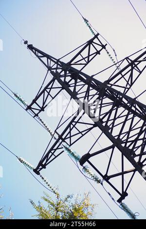 grande torre di ferro di linee elettriche in area verde sotto il cielo blu Foto Stock