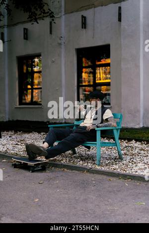 L'uomo bello ed elegante beve caffè, le sue mani sono coperte di tatuaggi. Foto Stock