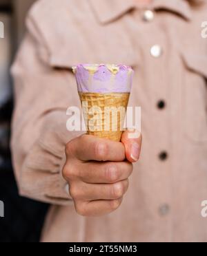 Cono gelato in foto ravvicinata a mano femminile. Foto Stock