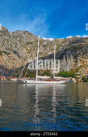35 m a vela Ketch ad Anchor al largo di Kotor con la scalinata di Kotor e la vecchia Fortezza di Kotor sullo sfondo. Foto Stock