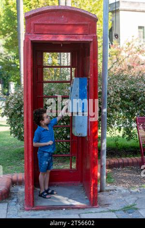 ragazzo dentro la vecchia cabina telefonica Foto Stock