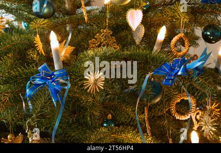 Candele. Palle archi e stella di paglia, decorazione sull'albero di Natale Foto Stock