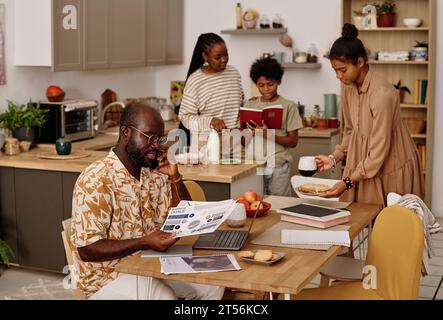 Famiglia nera che passa il tempo a casa, lavora e fa i compiti Foto Stock