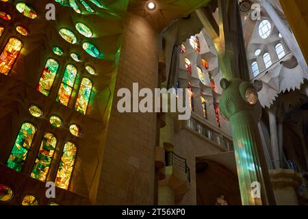 L'interno della Sagrada Familia a Barcellona, Spagna, mostra vetrate colorate e parte della facciata passione Foto Stock