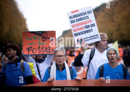 Letzte Generation blockade DEU, Deutschland, Germania, Berlino, 28.10.2023 Demonstranten der Initiative Letzte Generation Extinction Rebellion XR und Fridays for Future mit Plakat Klimakrise ist die groesste Gesundheitsgefagr fuer die Menschheit und Weg mit den Fossilien Brennstoffen bei der blockade unter dem motto VOR den Kipppinkten der Strasse 17. Juni in Berlin Deutschland . Die Gruppe fordert die Bundesregierung auf, drastischere Massnahmen zur Senkung der Treibhausgasemissionen zu ergreifen und bis 2030 Die Nutzung aller fossilen Brennstoffe einzustellen: Manifestanti dell'iniziativa Foto Stock