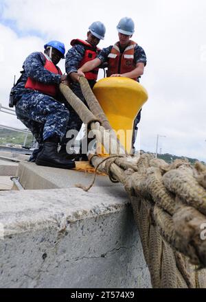 I gestori della US Navy Line mettono in sicurezza la nave d'assalto anfibio USS Essex (LHD 2) dispiegata in avanti a un molo a White Beach Naval Facil.jpg Foto Stock