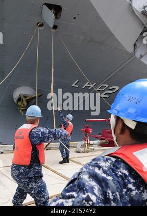 I gestori della US Navy Line mettono in sicurezza la nave d'assalto anfibio USS Essex (LHD 2) dispiegata in avanti a un molo a White Beach Naval Facil.jpg Foto Stock