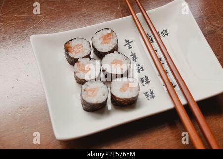 porzione di maki sushi al salmone servita su un piatto Foto Stock