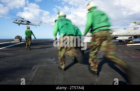 I marinai della Marina DEGLI STATI UNITI corrono per spostare il carico sul ponte di volo durante un rifornimento verticale a bordo della portaerei classe Nimitz US.jpg Foto Stock