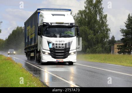 Nuovo autocarro Iveco S-Way Natural Power, NP alimentato a gas bianco, davanti al semirimorchio nel traffico stradale in una giornata di pioggia. Salo, Finlandia. 20 luglio 2023. Foto Stock