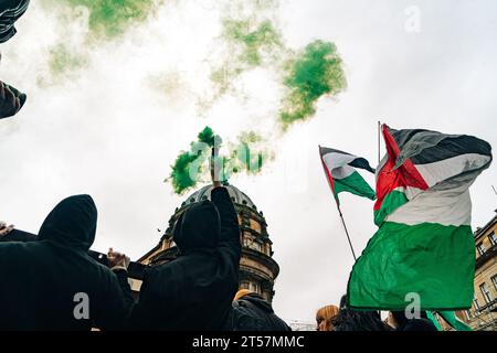 I manifestanti lanciano bombe fumogene verdi in aria, mentre le bandiere palestinesi ondeggiano di fronte all'architettura di Newcastle. Newcastle upon Tyne, Regno Unito - ottobre 28 2023. Foto Stock