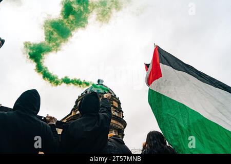 I manifestanti lanciano bombe fumogene verdi in aria, mentre le bandiere palestinesi ondeggiano di fronte all'architettura di Newcastle. Newcastle upon Tyne, Regno Unito - ottobre 28 2023. Foto Stock