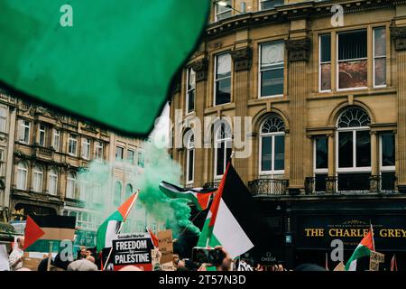 I manifestanti lanciano bombe fumogene verdi in aria, mentre le bandiere palestinesi ondeggiano di fronte all'architettura di Newcastle. Newcastle upon Tyne, Regno Unito - ottobre 28 2023. Foto Stock