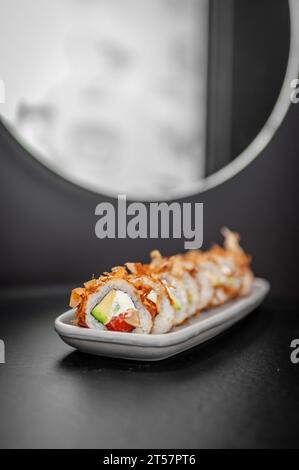 Sushi roll classico Bonito con fiocchi di tonno, salmone e avocado. Piatto giapponese con salmone fresco e riso. Foto di alta qualità Foto Stock