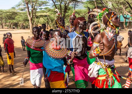 SOUTH HORR, KENYA - 12 FEBBRAIO 2020: Gruppo di giovani uomini e donne della tribù Samburu che ballano con copricapi colorati fatti di piume di struzzo dopo m Foto Stock