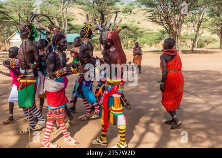 SOUTH HORR, KENYA - 12 FEBBRAIO 2020: Gruppo di giovani uomini e donne della tribù Samburu che ballano con copricapi colorati fatti di piume di struzzo dopo m Foto Stock