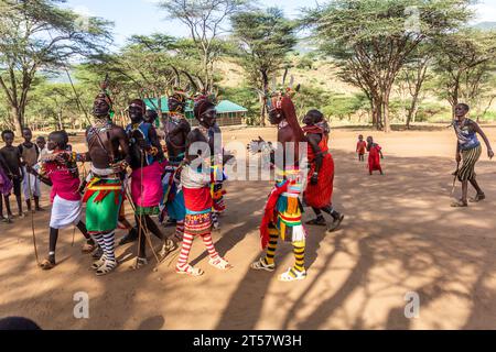 SOUTH HORR, KENYA - 12 FEBBRAIO 2020: Gruppo di giovani uomini e donne della tribù Samburu che ballano con copricapi colorati fatti di piume di struzzo dopo m Foto Stock