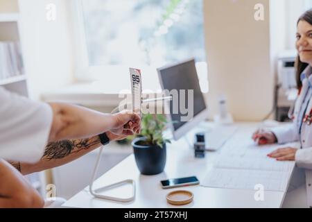 Il medico controlla la vista del suo giovane paziente. Foto Stock