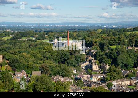 Clarence Mill a Bollington, vicino a Macclesfield, Cheshire, Inghilterra. La città di Manchester in lontananza. Foto Stock