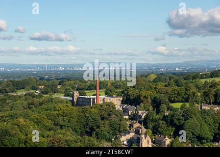 Clarence Mill a Bollington, vicino a Macclesfield, Cheshire, Inghilterra. La città di Manchester in lontananza. Foto Stock