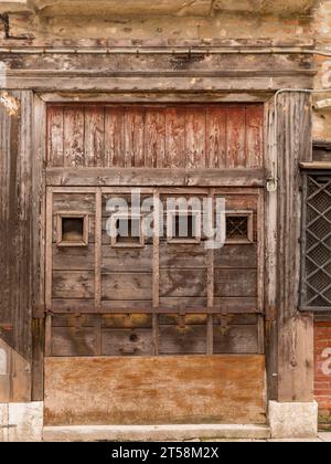 Vecchia porta di legno indossata dal tempo a Venezia, Italia. Foto Stock