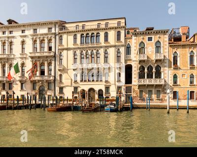 Palazzi veneziani lungo il Canal grande, Venezia, Italia. Le barche dell'ufficio regionale sono ormeggiate alla banchina. Foto Stock