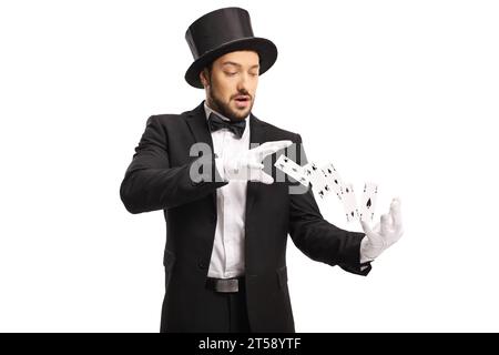 Mago che indossa guanti bianchi ed esegue un trucco con carte volanti isolate su sfondo bianco Foto Stock