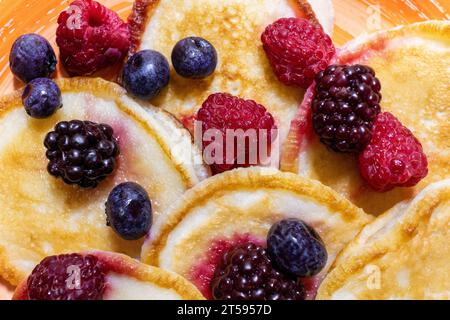 Primi piani deliziosi pancake, con mirtilli freschi, lamponi e more, lo sfondo di un delizioso dessert Foto Stock