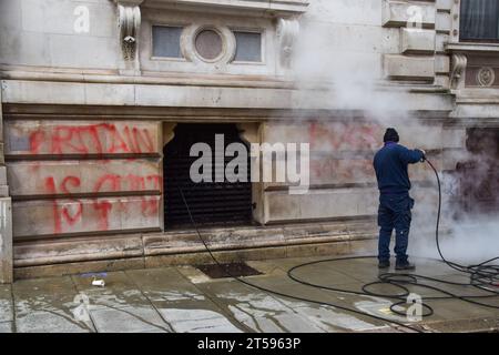 Londra, Regno Unito. 3 novembre 2023. Un lavoratore pulisce i graffiti dopo che i manifestanti pro-Palestina hanno spruzzato l'edificio Foreign, Commonwealth and Development Office a Westminster con vernice rossa e ha scritto "Britain is Guilty” (la Gran Bretagna è colpevole) mentre la guerra Israele-Hamas si intensifica. Credito: SOPA Images Limited/Alamy Live News Foto Stock