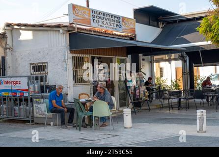 Gli uomini siedono fuori da un bar/negozio di souvenir nel centro di Larnaca, Cipro Foto Stock