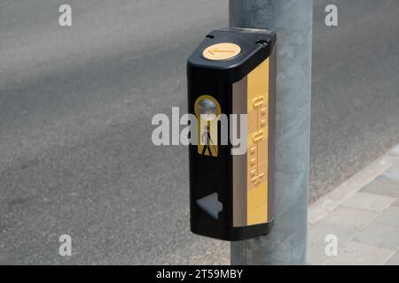 pulsante, posizionato in corrispondenza delle passerelle. il pulsante tattile, montato su un palo, funge da strumento essenziale per i non vedenti per attraversare la strada in sicurezza Foto Stock