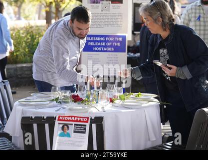 Clayton, Stati Uniti. 3 novembre 2023. I volontari accendono le candele ad un tavolo dello Shabbat a Clayton, Missouri, venerdì 3 novembre 2023, mentre la comunità ebraica ricorda 239 uomini, donne e bambini che sono stati presi in ostaggio dai militanti di Hamas il 7 ottobre 2023. La cena di Shabbat è gustata dagli ebrei il venerdì sera, ma lo spettacolo è stato creato con una foto e un nome per ogni persona presa in ostaggio nella speranza simbolica di tornare in sicurezza. Foto di Bill Greenblatt/UPI credito: UPI/Alamy Live News Foto Stock