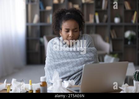 Malato malato malato malato paziente remoto nero avvolto in un plaid caldo Foto Stock