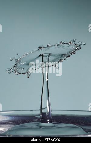 due gocce d'acqua si scontrano e causano schizzi con la corona e picchi Foto Stock