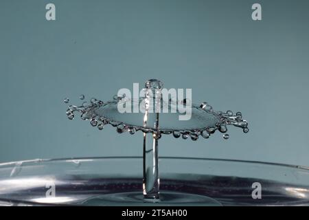 due gocce d'acqua si scontrano e causano schizzi con la corona e picchi Foto Stock