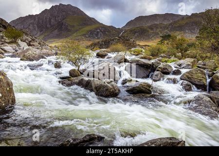 Parte superiore delle cascate Ogwen da Pont Pen-y Benglog, con il monte Tryfan sullo sfondo, Llyn Ogwen, Snowdonia, Galles Foto Stock