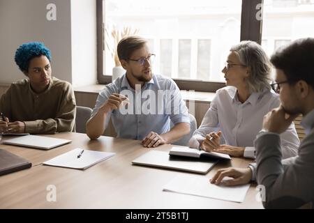 Giovane professionista professionista che condivide idee con il team Foto Stock