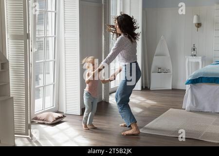 Madre e figlia che ballano in una camera da letto accogliente Foto Stock