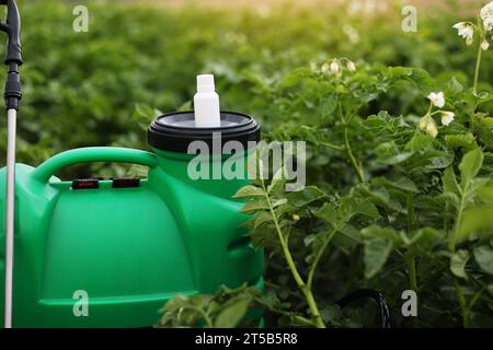 Piccola bottiglia bianca di pesticida, erbicida per proteggere le piante da malattie e parassiti con supporti mock up su spruzzatore contenitore su ga verde naturale Foto Stock