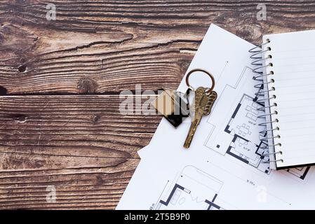 I tasti della casa da vicino disegnano il nuovo notebook a spirale con sfondo in legno Foto Stock