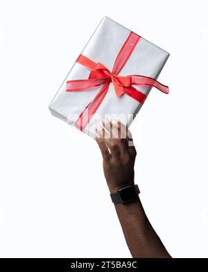 Primo piano della mano maschile che solleva il regalo di Natale con le feste di Natale con sfondo bianco Foto Stock