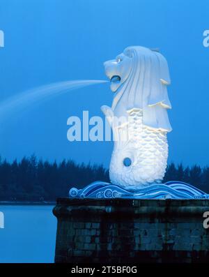 Singapore. Merlion Park. Fontana della statua di Merlion illuminata di notte. Foto Stock